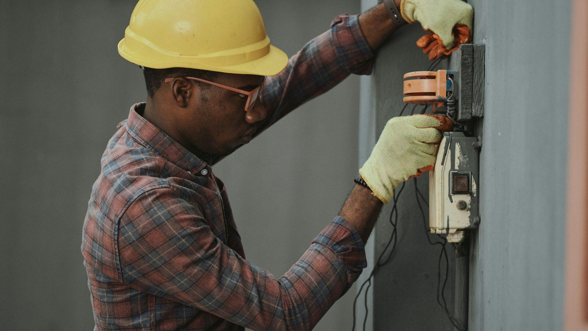 profile photo of an electrician in a yellow hard hat working